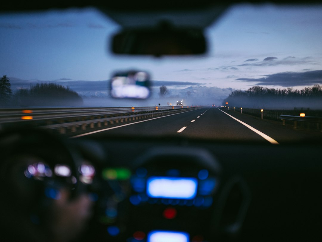 Painel de um carro em estrada tranquila ao entardecer